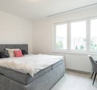 Bright bedroom with a bed and a view in a 3-room apartment.
