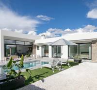 The villa in Calasparra has a swimming pool, a terrace with loungers, and a parasol under the blue sky.