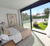 A bright interior of a villa with a bed, artwork, and a view of the garden.
