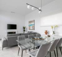 Living room in a villa with a glass table, gray armchairs, and decorations.