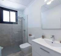 Bathroom in a villa with a sink, toilet, shower, and large mirror.