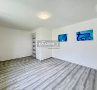 A spacious room with wooden flooring and abstract paintings in a family house.