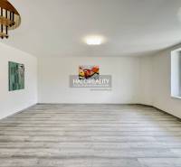 In the family house, there are wooden stairs, paintings on the walls, and a large window.