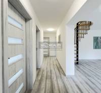 Interior of a family house with a wooden staircase and light-colored doors, floor with a wooden appearance.