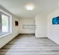 The interior of a family house room with a large window and abstract paintings on the walls.