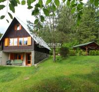 A cottage in Dolná Lehota surrounded by greenery and a garden gazebo on a grassy area.