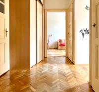 Hallway in a 2-room apartment with wooden doors and parquet flooring.