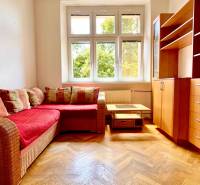 Wooden floor, corner sofa with red upholstery, living room set, window with a view.