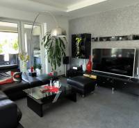 Living room in a family house with a leather sofa, television, and modern decor.
