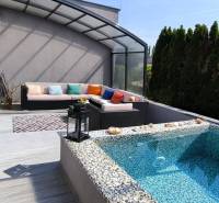 The terrace of a family house in Zurndorf with a swimming pool and seating under a shelter.