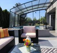 The terrace of a family house in Zurndorf with seating by the pool and glass sliding doors.