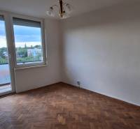 A room in a 3-room apartment with a wooden floor, balcony, city view.