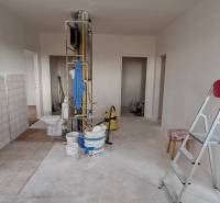 Interior of a 3-room apartment before renovation with a ladder, buckets, and tools.