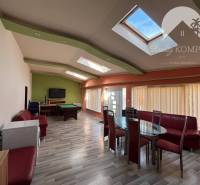 Interior of a family house with a billiard table, television, and a dining area with seating.