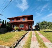 A family house in Trávnik with a well-maintained garden and a paved walkway.