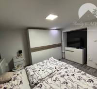 A bedroom in a family house with a double bed, a wardrobe, and a television.