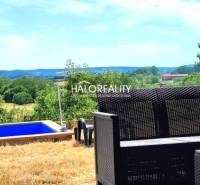 View of the green gardens from the garden in Lučenec with a pool and seating.