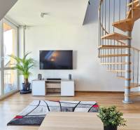 Living room with a television, staircase, and a plant in a 4-room apartment.