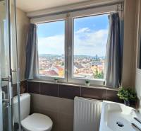 A bathroom in a 4-room apartment with a window and a view of the city.