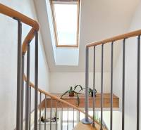 A staircase with a wooden railing and a skylight in a 4-room apartment.
