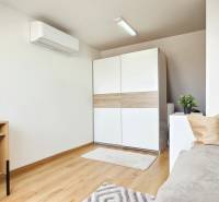 4-room apartment with a desk, sofa, wardrobe, and air conditioning on the wall.
