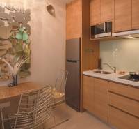 A kitchen in a 2-room apartment with a mirror and gray chairs.