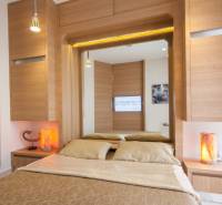 A stylish bedroom in a 2-room apartment with wooden elements and a large mirror.