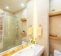 Elegant bathroom in a 2-room apartment with a shower and decorative lighting.
