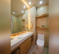 Bathroom in a 2-room apartment with a bathtub, sink, and toilet, wooden and ceramic details.