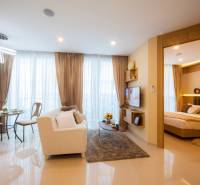 Living room with dining area and entrance to the bedroom in a three-room apartment.