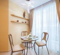 Dining area with a table and chairs in a 3-room apartment, illuminated by a chandelier.