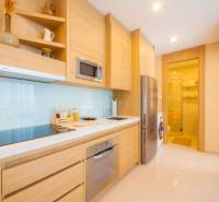 A kitchen in a 3-room apartment with wooden cabinets and appliances.