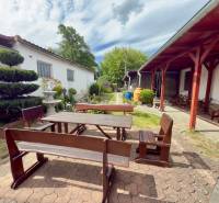 The garden of a family house in Koválov with wooden seating and well-maintained greenery.