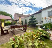 The garden of a family house in Koválov with wooden seating and floral decorations.