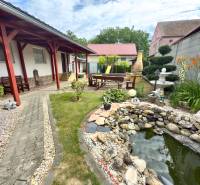 A family house in Koválov with a courtyard, gazebo, pond, and outdoor seating.