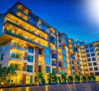 Apartment construction in Pattaya in the evening, illuminated modern apartment complex, logo 1BCR, verified member.