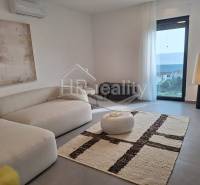 Recreational apartment with comfortable seating, large window, and sea view.