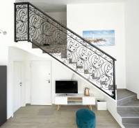 Interior of a holiday apartment with a television, staircase, and decorative railing.