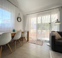 The holiday apartment offers a bright living space with a dining table and a comfortable sofa.
