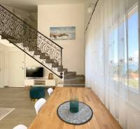 A recreational apartment with a wrought iron staircase and dining table, sea view.