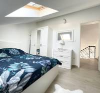 A bedroom in a holiday apartment with a bed, wardrobe, and skylight.
