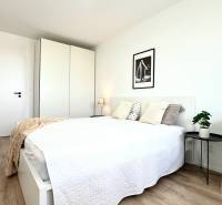 Bright bedroom with a bed, wardrobe, and desk in a 2-room apartment.