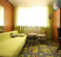 Children's room in a family house with a green sofa, a desk, and a decorative carpet.