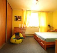 A yellow room in a family house with wooden furniture and a comfortable armchair.