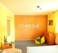 Yellow room in a family house with a bed, cabinet, and bean bag.