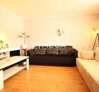 Living room of a family house with sofas, a table, and decorations on the walls.