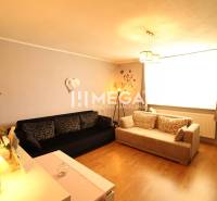 Living room in a family house with sofas and wooden flooring.