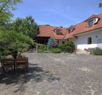 A family house in Podbranč with a landscaped garden and outdoor seating on paving stones.