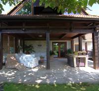 A covered terrace of a family house in Podbranč with comfortable rattan seating and a table.