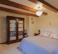 A bedroom with wooden beams and an elegant wardrobe in a family house.